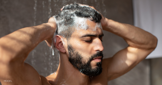 man with eyes closed, shampooing his hair in the shower